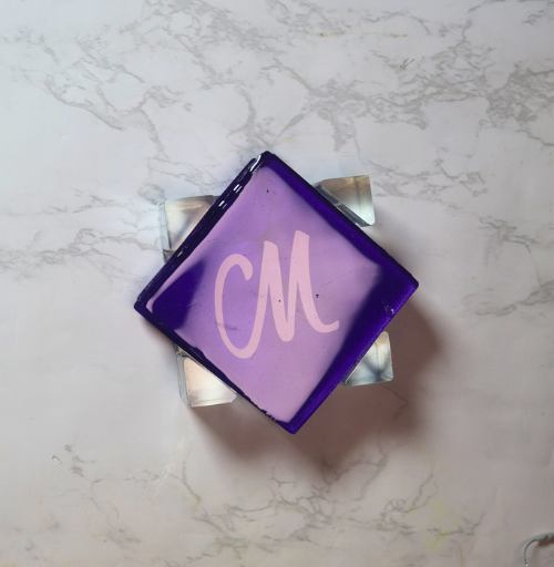 Purple handmade resin coaster set with four square coasters featuring custom initials and matching holder